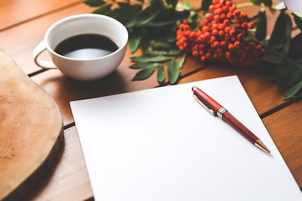 tisch mit kaffetasse papier und stift